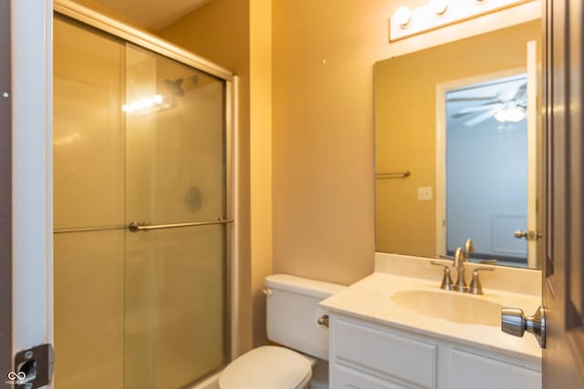 full bathroom featuring a stall shower, vanity, toilet, and a ceiling fan