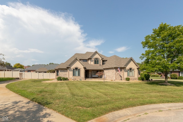 french country inspired facade featuring fence and a front lawn