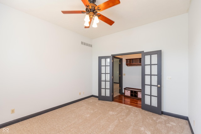 unfurnished room featuring carpet, visible vents, baseboards, and french doors