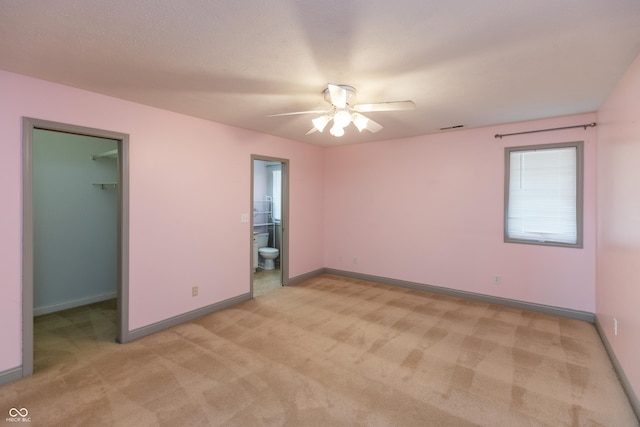 empty room with a ceiling fan, light carpet, visible vents, and baseboards