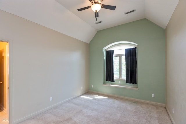 spare room featuring lofted ceiling, carpet, visible vents, and baseboards