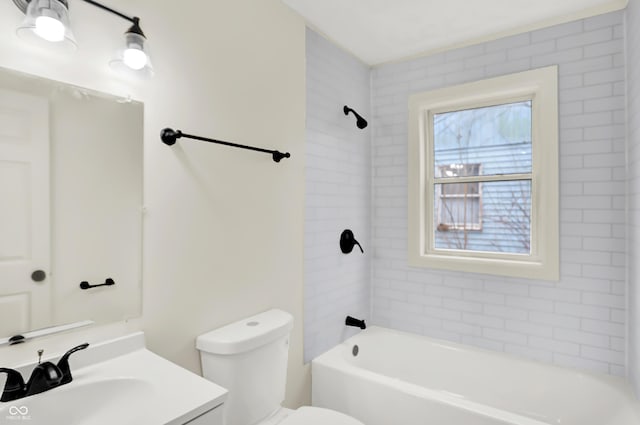 full bathroom with tiled shower / bath, vanity, and toilet