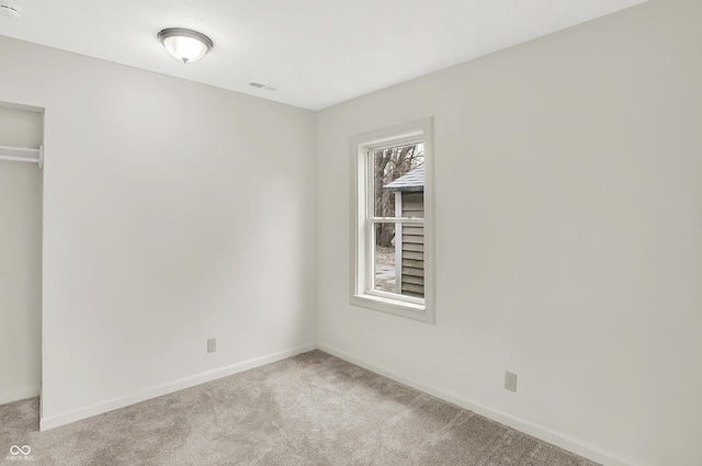 unfurnished bedroom featuring light colored carpet and a closet