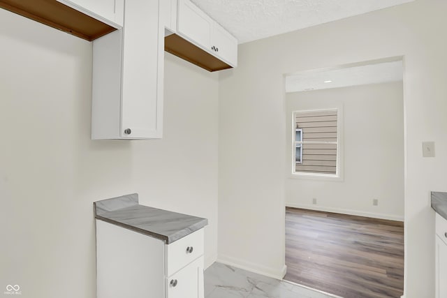 kitchen with white cabinets and a textured ceiling