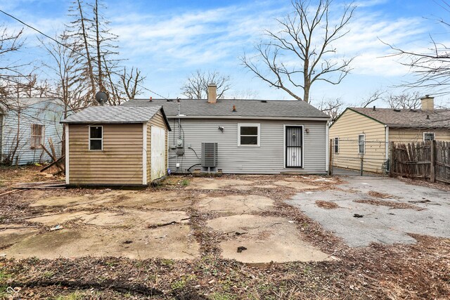 rear view of property featuring a storage unit