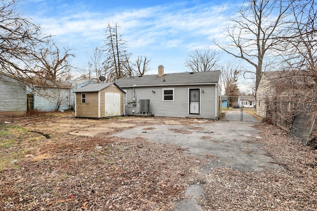 rear view of property with a storage shed