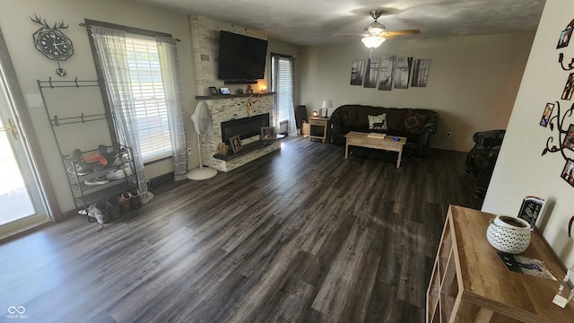 living room with a fireplace, dark hardwood / wood-style flooring, plenty of natural light, and ceiling fan