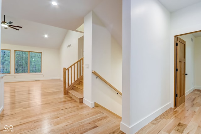 interior space with vaulted ceiling, an upstairs landing, light wood finished floors, baseboards, and recessed lighting