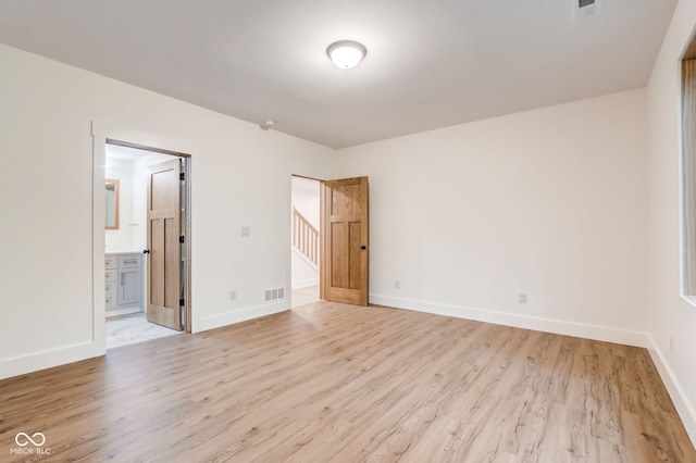unfurnished bedroom with light wood-type flooring, visible vents, and baseboards