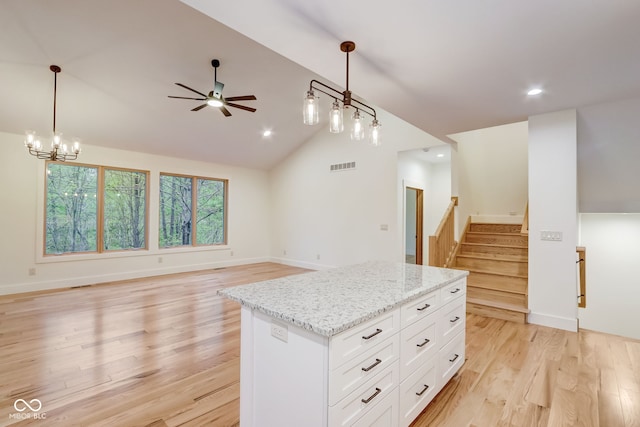 kitchen with decorative light fixtures, visible vents, a center island, and open floor plan