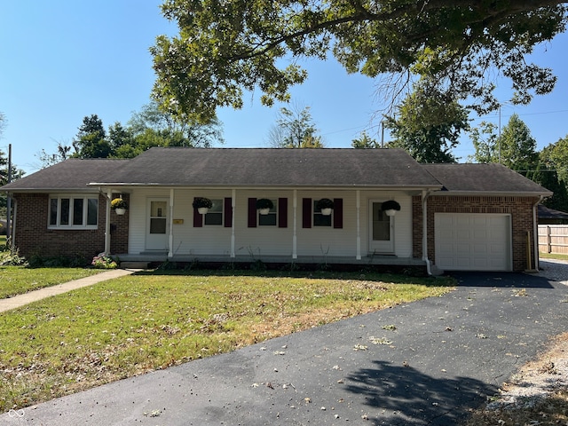 ranch-style house with covered porch, a front yard, and a garage