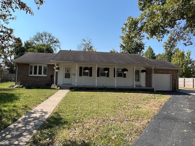 ranch-style house featuring a front yard, a garage, and covered porch