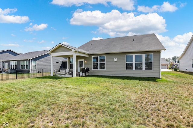 back of property with a yard and a patio