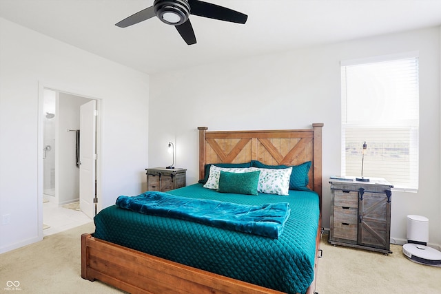 bedroom with ceiling fan, carpet flooring, and ensuite bath