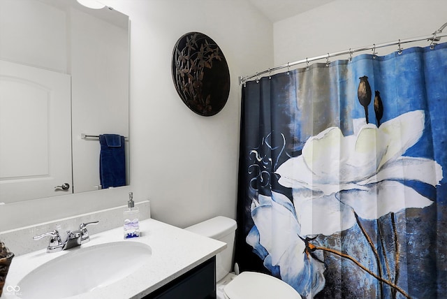 bathroom with walk in shower, vanity, and toilet