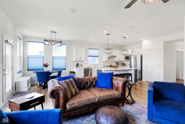 living room with ceiling fan, light hardwood / wood-style flooring, and plenty of natural light