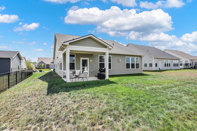 back of house with a patio and a lawn