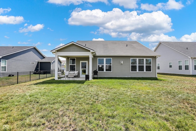 back of property with a lawn and a patio area