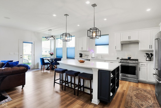 kitchen featuring a healthy amount of sunlight, white cabinetry, a center island, and stainless steel appliances