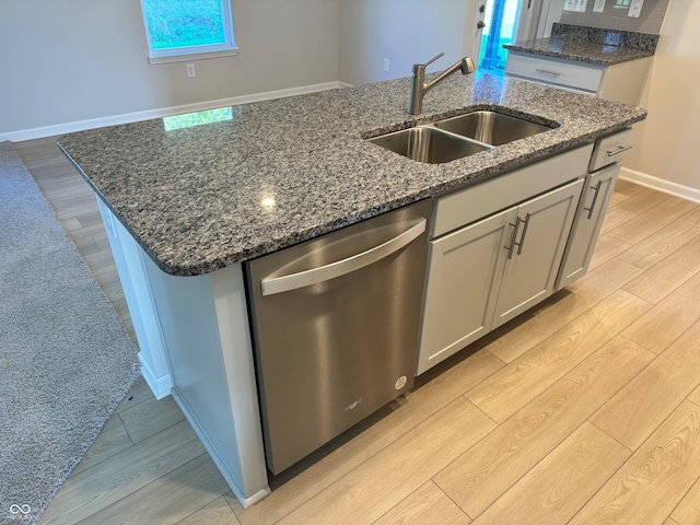 kitchen with light hardwood / wood-style flooring, a center island with sink, sink, and stainless steel dishwasher