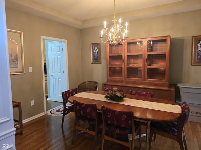 dining area with baseboards, an inviting chandelier, and dark wood-style flooring