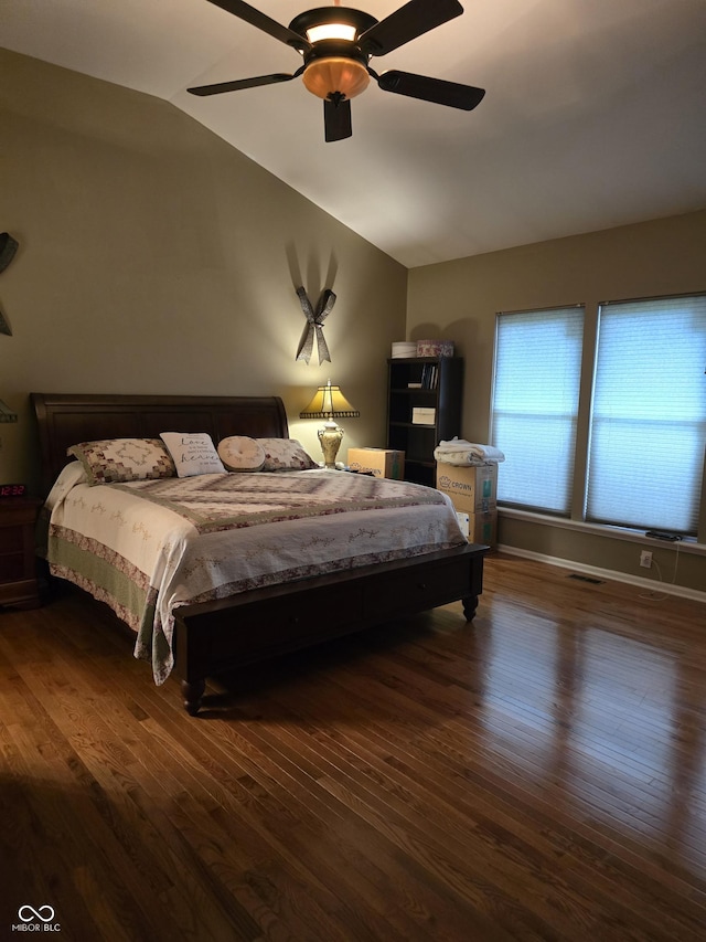 bedroom with visible vents, lofted ceiling, wood finished floors, and a ceiling fan