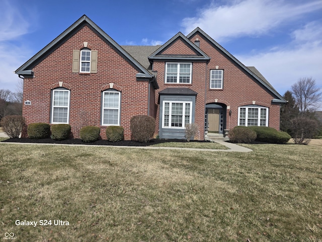 view of front of property featuring brick siding and a front yard