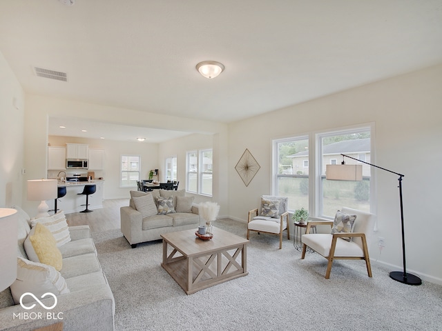 living area featuring recessed lighting, visible vents, and baseboards