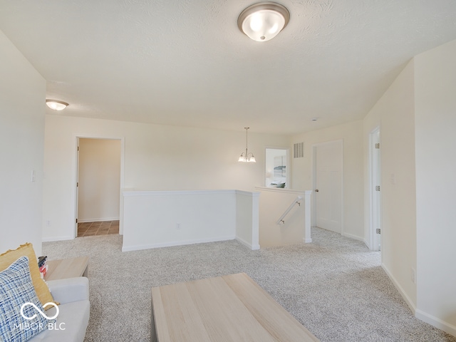 unfurnished living room featuring baseboards, visible vents, and light colored carpet