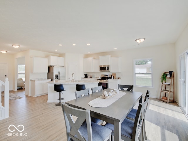 dining area with light wood-type flooring, baseboards, and recessed lighting