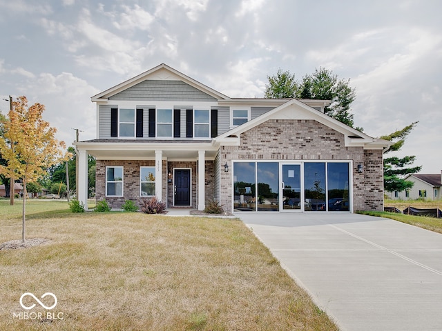 view of front of property with brick siding, driveway, and a front lawn