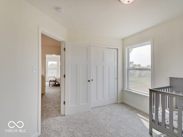 carpeted bedroom featuring baseboards and a closet