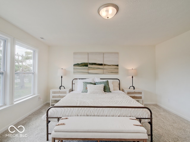 carpeted bedroom with visible vents and baseboards