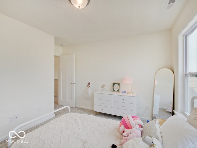 bedroom featuring baseboards, visible vents, and light colored carpet