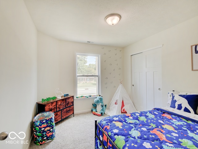 bedroom with a closet, carpet, visible vents, and baseboards