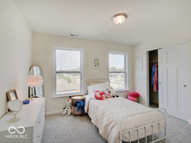 bedroom with carpet floors, baseboards, visible vents, and a closet