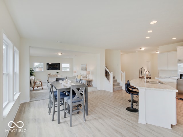 dining space with light wood-style floors, stairs, and recessed lighting