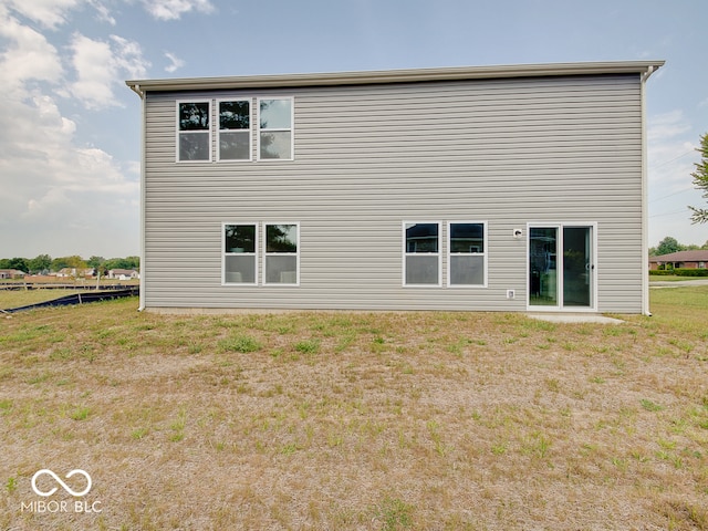 rear view of property with a lawn