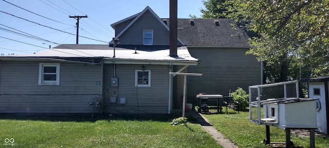 rear view of house featuring a lawn