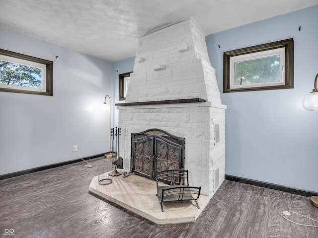 living room with a textured ceiling, dark hardwood / wood-style flooring, and a fireplace