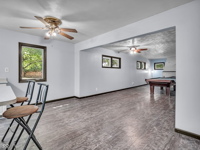 interior space with dark wood-type flooring, pool table, and ceiling fan