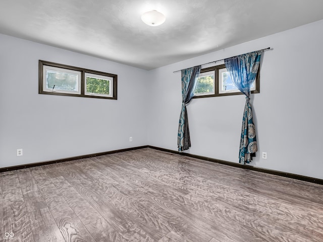 empty room with wood finished floors and baseboards