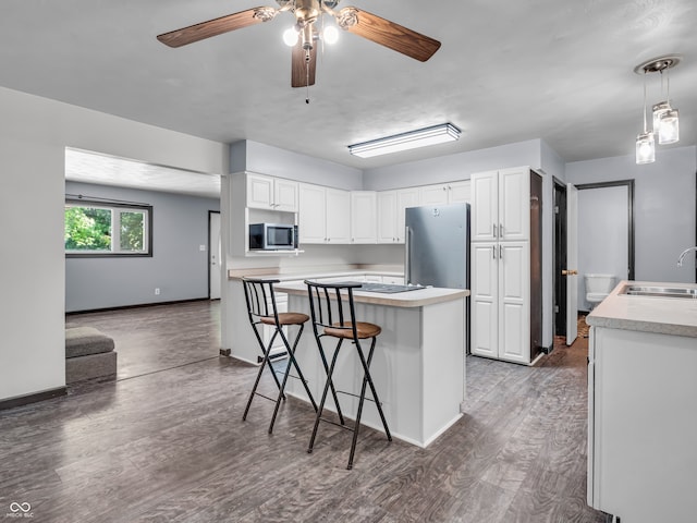 kitchen featuring ceiling fan, sink, appliances with stainless steel finishes, and white cabinetry