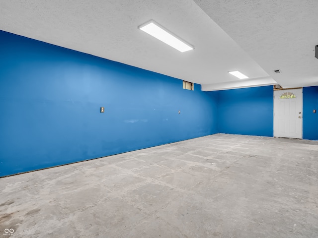 spare room featuring a textured ceiling and concrete floors