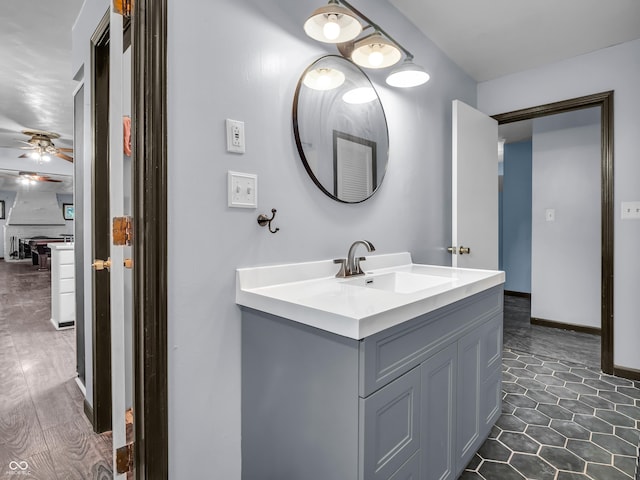 bathroom with ceiling fan, vanity, and baseboards