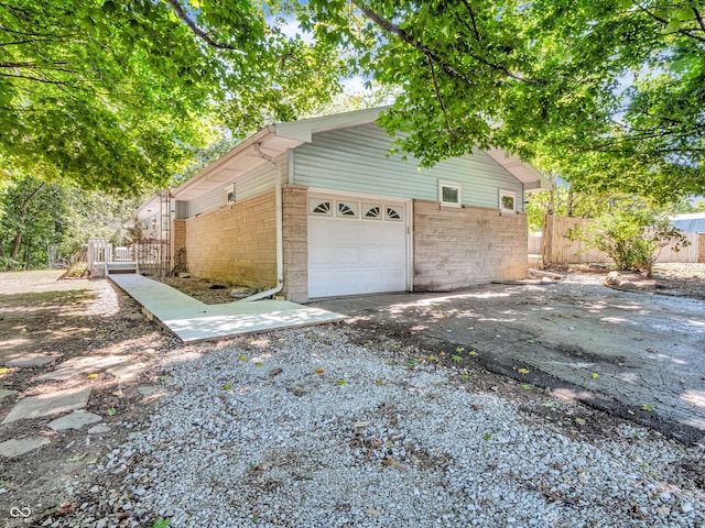 garage with aphalt driveway and fence