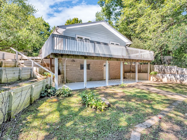 rear view of property with a yard, a patio, and a deck