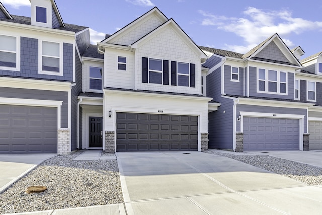 view of front of home with a garage, concrete driveway, and brick siding