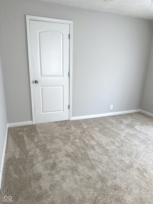 carpeted empty room featuring a textured ceiling