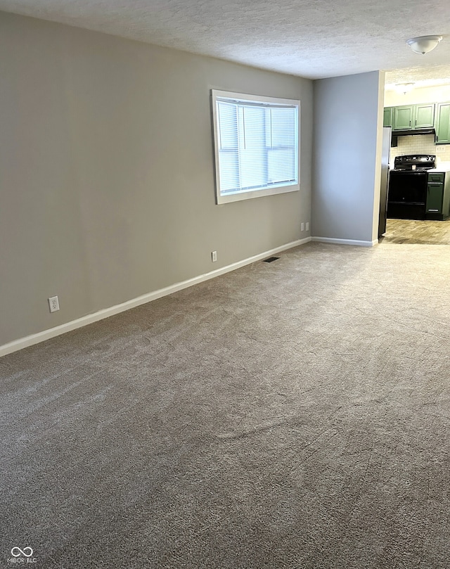 carpeted empty room with a textured ceiling